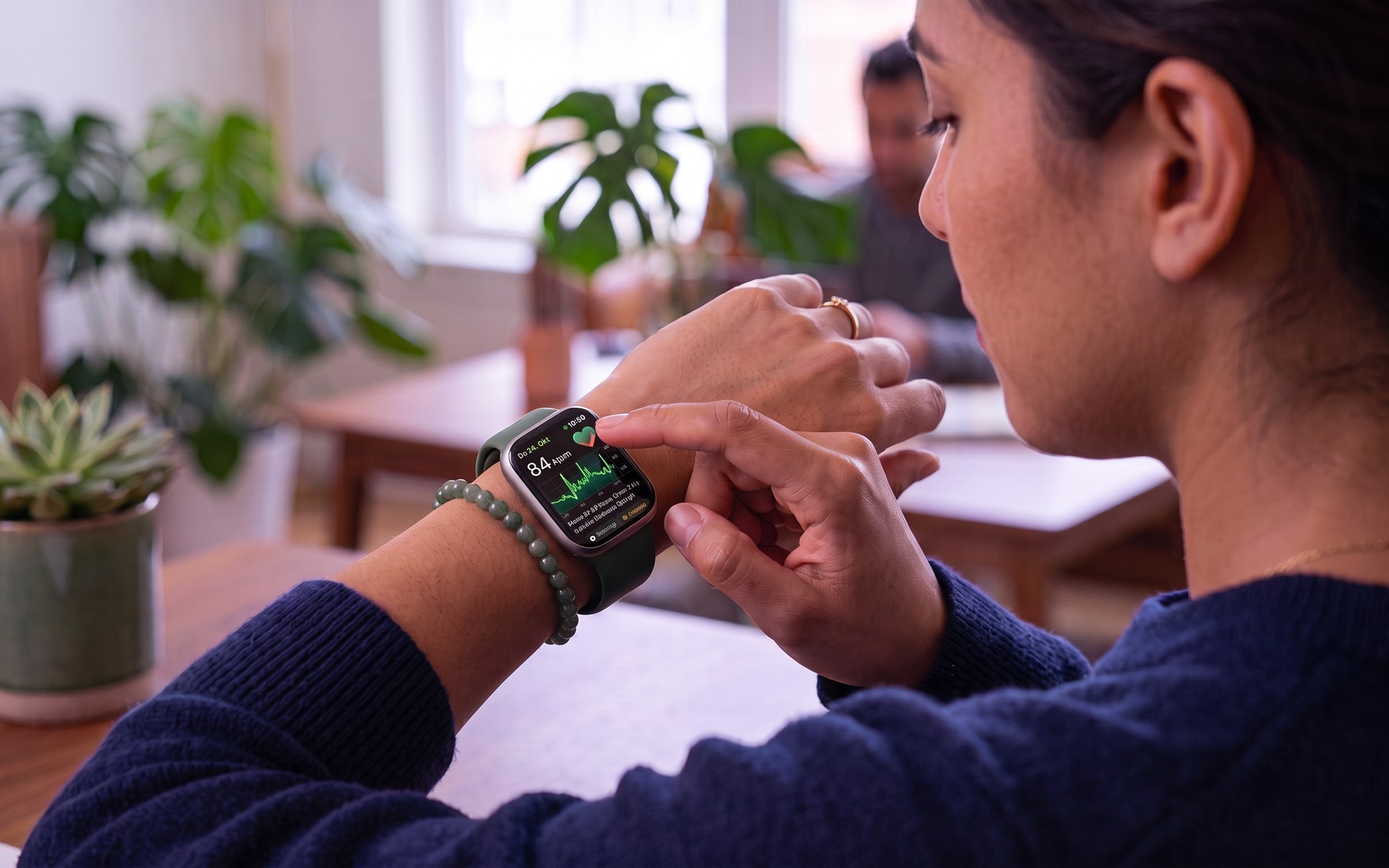 Person checking heart rate on a smartwatch at a table